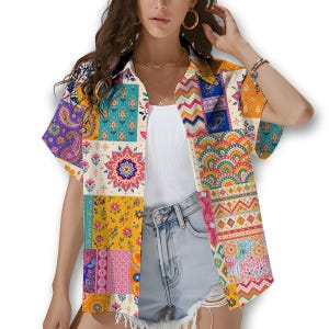 May include: A colourful patchwork shirt with short sleeves, featuring a variety of patterns including paisley and floral designs. The shirt's palette includes purple, yellow, orange, and blue. It has a collared neckline and is worn open.