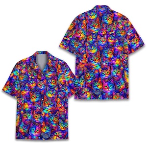 May include: Two short-sleeved button-down shirts with a vibrant, psychedelic cat pattern. The shirts feature a repeating design of colorful cat faces in shades of blue, purple, yellow, and green. The shirts have a classic collar and button closure.