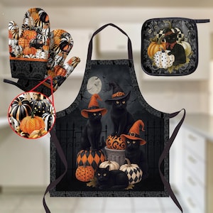 May include: A Halloween kitchen set featuring an apron, an oven mitt, and a pot holder. The apron displays three black cats wearing orange witch hats amidst pumpkins and a fence. The mitt and pot holder feature a repeating pumpkin pattern.