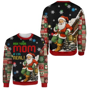 May include: A black long-sleeve sweatshirt featuring a graphic of Santa Claus leaning against a house with the text "ASK YOUR MOM IF I'M REAL!" in red and yellow. The sleeves and sides have a red, green, and white patterned knit design.