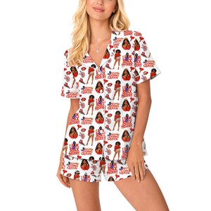 May include: White pajama set with a repeating pattern of Black women, red lips, sneakers, and the text "I AM BLACK HISTORY QUEEN" and "KEEP GOING". The short-sleeved top and shorts set is made of a soft material.