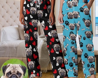 May include: A pair of black and white pajama pants with a heart and pug dog pattern. The pants have an elastic waistband and a drawstring. The pants are shown on a model.