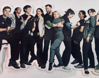 May include: A die-cut sticker featuring a group of people in medical scrubs, some with stethoscopes. The sticker has a white border and depicts a diverse group of healthcare professionals in various poses, including hugging and smiling.