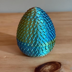 May include: A blue and green dragon egg-shaped trinket with a scaly texture.