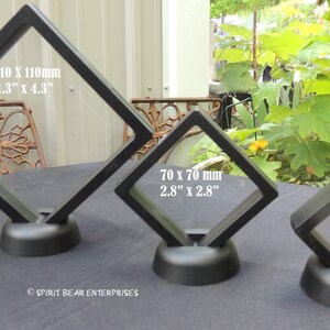 May include: Three black diamond-shaped display stands with clear acrylic panels. The stands are different sizes: 4.3 inches by 4.3 inches, 2.8 inches by 2.8 inches, and 2 inches by 2 inches.