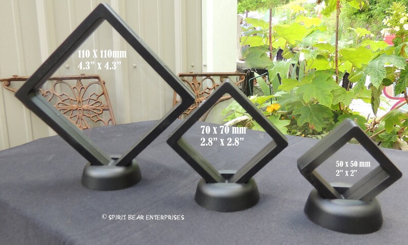 May include: Three black diamond-shaped display stands with clear acrylic panels. The stands are different sizes: 4.3 inches by 4.3 inches, 2.8 inches by 2.8 inches, and 2 inches by 2 inches.