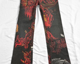 Peut inclure: Jean en denim délavé foncé avec des motifs floraux et graphiques rouges et jaunes. Le jean présente un tournesol à l'avant et diverses illustrations. Le jean a une coupe droite et est posé à plat sur une surface blanche.