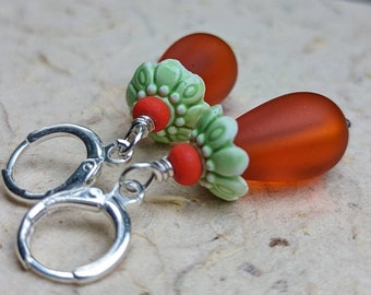 Boucles d’oreilles pendantes fantaisistes orange et vert, larmes de verre orange surmontées de capuchons de perles de fleur vert printemps argent Levierback earwires