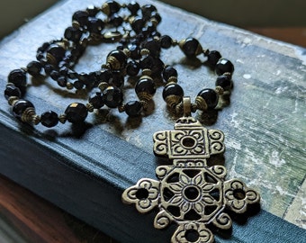 Superbe grand collier long croix éthiopien en laiton, avec des perles tibétaines du Népal coiffées en laiton d'onyx noir et des perles à facettes en verre tchèque