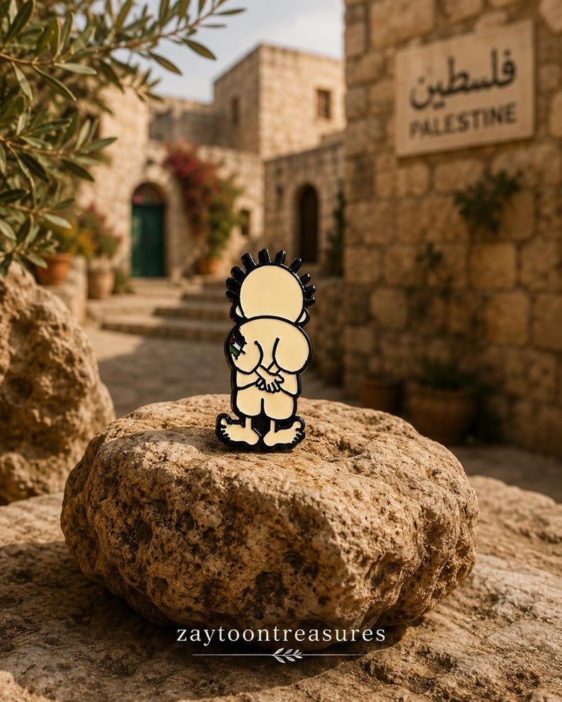 May include: A metal enamel pin featuring a cartoon character with spiky black hair, seen from behind with hands clasped, wearing light-colored clothing. The character has a small flag detail on the arm. The pin has a black outline and base.