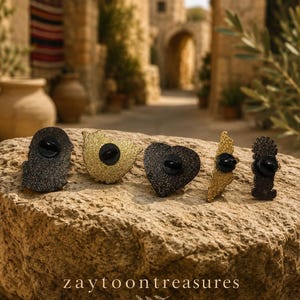 May include: Five glittery enamel pins in various shapes including a heart and map outlines, each featuring a black rubber clutch backing. The pins are displayed on a textured stone surface with the text zaytoontreasures printed at the bottom.
