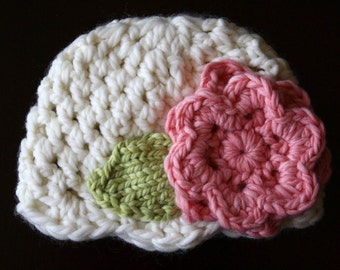 Peut inclure: Chapeau crocheté blanc avec une applique de fleur rose et verte.
