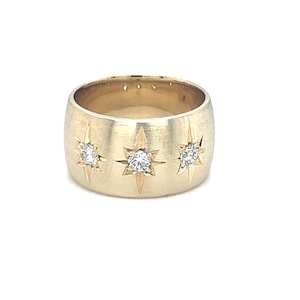 Gold cigar band ring with three diamonds and starburst engraving celestial stars