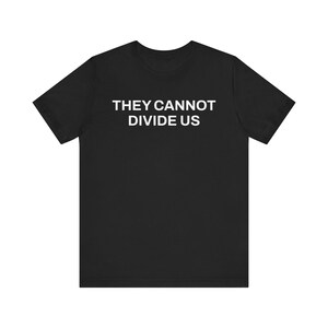 May include: Black t-shirt with the white text "THEY CANNOT DIVIDE US" printed on the front. The shirt features a crew neck and short sleeves, made from a soft fabric.