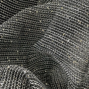 May include: Black fabric with a fine, woven texture and a subtle shimmer from gold sequins.