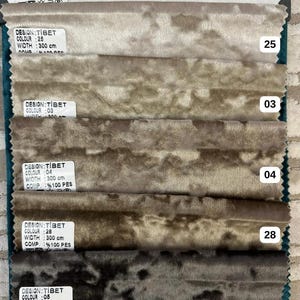 K&ouml;nnte beinhalten: Ein Stoffmusterbuch mit sechs Streifen aus Knitter-Samt in einem Verlauf von neutralen T&ouml;nen von Wei&szlig; bis Dunkelgrau. Jedes Muster enth&auml;lt ein wei&szlig;es Etikett mit dem Text DESIGN: TIBET, WIDTH: 300 cm und COMP: 100 PES.