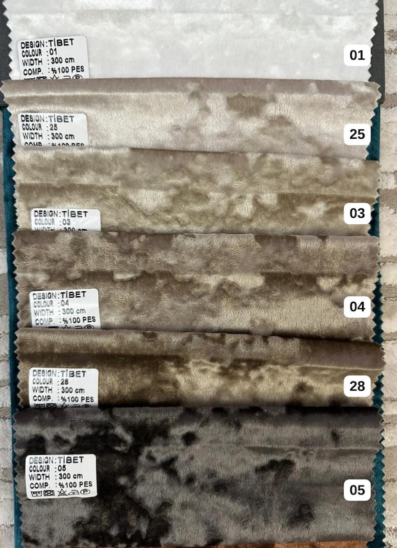 K&ouml;nnte beinhalten: Ein Stoffmusterbuch mit sechs Streifen aus Knitter-Samt in einem Verlauf von neutralen T&ouml;nen von Wei&szlig; bis Dunkelgrau. Jedes Muster enth&auml;lt ein wei&szlig;es Etikett mit dem Text DESIGN: TIBET, WIDTH: 300 cm und COMP: 100 PES.