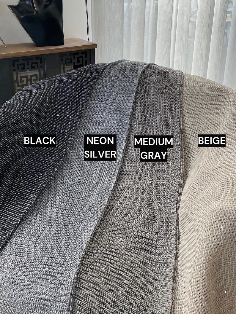 May include: Four fabric swatches in black, silver, grey, and beige. Each swatch has a sparkly, textured surface.