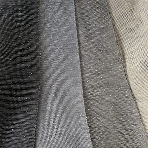 May include: A close-up of a woven throw blanket with three sections in shades of grey. The blanket is made of a soft, textured material.