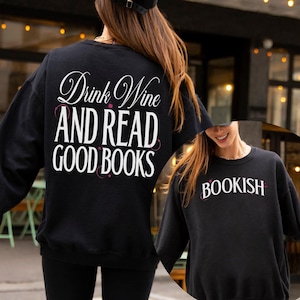 Könnte beinhalten: Zwei schwarze Langarmshirts mit weißem Text. Das erste Shirt sagt "Drink Wine And Read Good Books". Das zweite Shirt sagt "Bookish".
