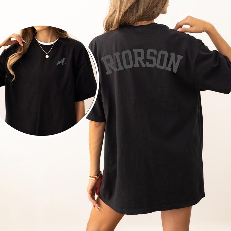 May include: Black oversized t-shirt with the word "RIORSON" printed in white on the back.
