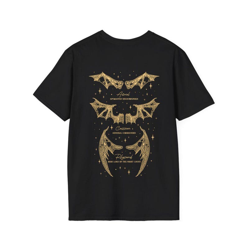May include: Black t-shirt featuring gold-colored illustrations of bat-like wings and text. The text includes names and titles: Azriel, Spymaster Shadowsinger; Cassian, General Commander; and Rhysand, High Lord of the Night Court.