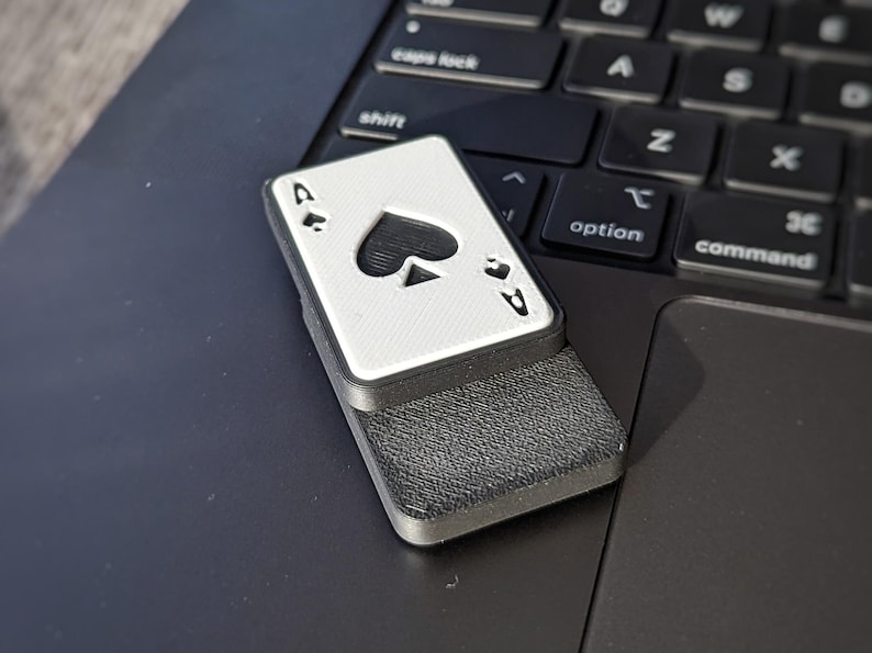Office Spielzeug, der Ass Fidget Slider. Der Slider liegt auf einem Macbook.