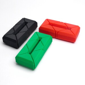 May include: Three geometric puzzle toys in black, green, and red. Each toy is made of interlocking pieces that can be rearranged into different shapes.