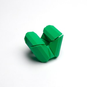 May include: A green geometric puzzle toy with multiple interlocking pieces. The toy is made of plastic and is designed to be folded and unfolded.