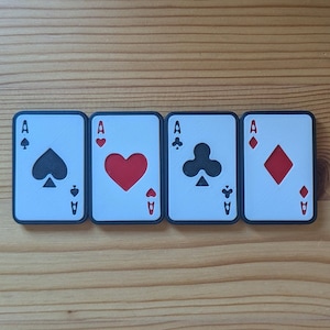 May include: Four playing cards, each with a different suit: spades, hearts, clubs, and diamonds. Each card is an ace and has a black border.