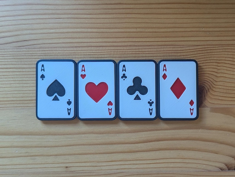 May include: Four playing cards, each with a different suit: spades, hearts, clubs, and diamonds. Each card is an ace and has a black border.