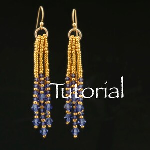 May include: Gold and purple beaded dangle earrings. The earrings have a gold chain with purple crystal beads hanging from the bottom.
