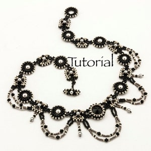 May include: A black and silver beaded necklace with a central pendant featuring a large black crystal. The necklace has a delicate, feminine design with multiple strands of beads and a cascading effect.