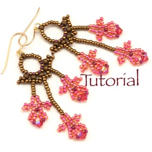 May include: A pair of beaded earrings with a gold-tone finish and pink and clear beads. The earrings feature a dangling design with multiple strands of beads. The word "Tutorial" is visible in the image.