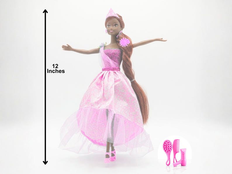May include: A 12-inch doll in a pink princess gown with a matching tiara and shoes. The doll has long brown hair and is accessorized with pink earrings and a flower. Includes pink hair accessories.