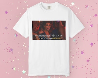 May include: A white short-sleeved t-shirt featuring a rectangular graphic print of a person with the text "EVERYONE SHUT THE FUCK UP IT'S MY FUCKING BIRTHDAY" centered below the image. The shirt has a crew neckline and a standard fit design.