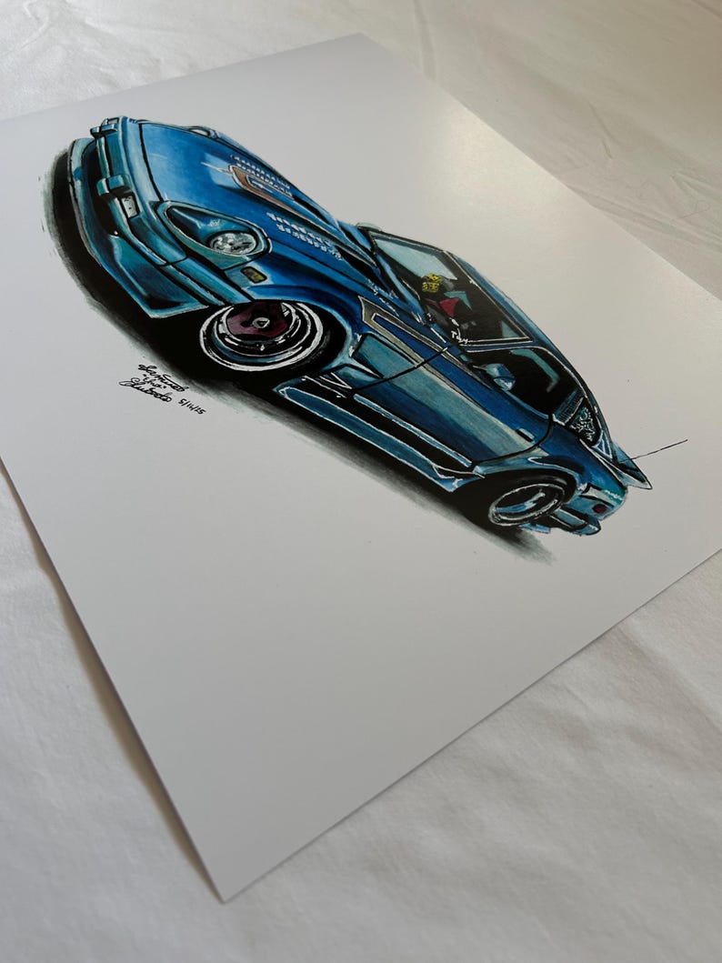 May include: A detailed illustration of a blue sports car with a low profile and custom wheels. The artwork features shading and highlights, giving the car a three-dimensional appearance. The car has a spoiler and a detailed interior. The artist's signature is visible.