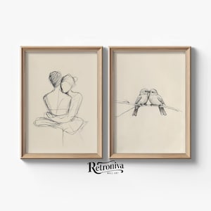 Pode incluir: Duas ilustrações emolduradas, uma representando um casal se abraçando e a outra mostrando dois pássaros se beijando em um galho.