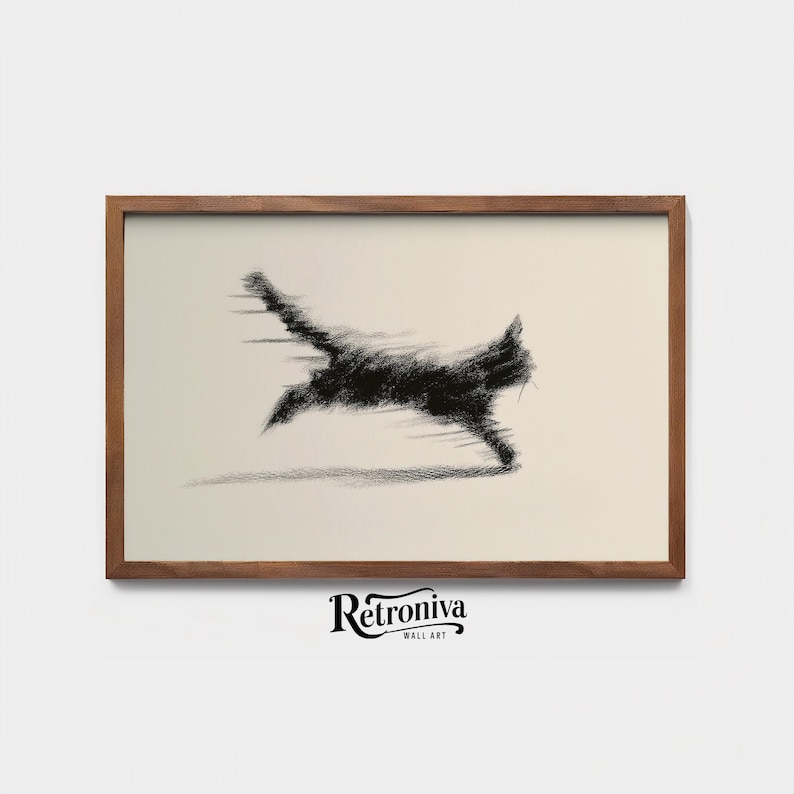 May include: A framed wall art print featuring a black cat in motion, rendered in a sketch-like style. The cat is depicted mid-leap against a cream-colored background. The frame is made of wood. The artwork is branded with the text "Retroniva Wall Art".