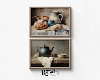 May include: Two framed still life paintings. The top painting shows a white pitcher, a blue bowl, and bread on a white tablecloth. The bottom painting shows a black teapot, a white bowl, and a white cloth on a wooden table.