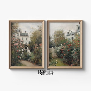 May include: A pair of framed paintings depicting a garden scene with a white house in the background. The garden is filled with lush greenery and pink and white flowers. The paintings are framed in a light wood frame.