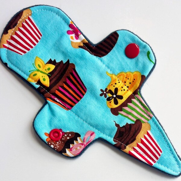 Protector diario tipo tanga de algodón Cupcakes de 19 cm con forro polar, 100 % reutilizable. Producto sostenible y ecológico.