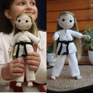 Könnte beinhalten: Eine gehäkelte Puppe, die einen weißen Karate-Anzug mit einem schwarzen Gürtel trägt. Die Puppe hat langes blondes Haar und braune Augen.