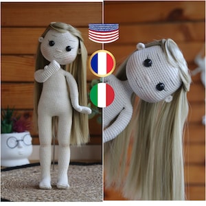 Peut inclure: Une poupée en crochet avec de longs cheveux blonds. La poupée est debout sur une surface en bois. La poupée porte une tenue blanche. La poupée a une expression neutre sur son visage.