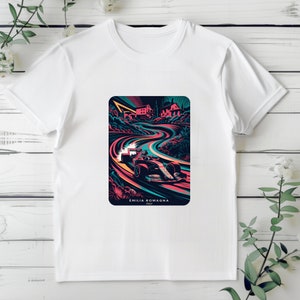 May include: White t-shirt with a colorful graphic print of a race car driving on a winding road. The graphic includes the text "Emilia Romagna" and "Italy".