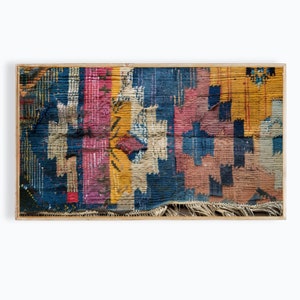 May include: A close-up of a colourful, woven rug with a distressed, vintage look. The rug features a variety of colours, including blue, red, yellow, and white. The rug is made of a thick, textured fabric and has a fringe border.