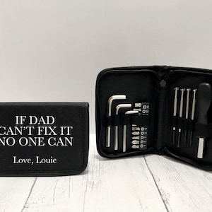 May include: Black tool kit with the text "IF DAD CAN'T FIX IT NO ONE CAN Love, Louie." The kit is open, showing various tools, including Allen keys and screwdrivers. The tools are silver and black.
