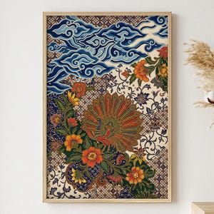 Op de afbeelding: Een rechthoekige wandkunstprint in een lichthouten lijst met een levendig batik-patroon. Het ontwerp toont een centrale pauw met een uitgewaaierde staart, omringd door oranje bloemen, groene bladeren en blauwe wolkenmotieven op een crèmekleurige achtergrond.