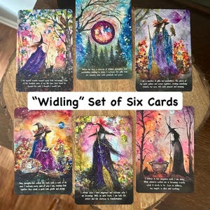 May include: A set of six rectangular cards titled Widling, each featuring colorful, painterly illustrations of figures in pointed hats, owls, cats, and magical landscapes. Each card includes printed text at the bottom in a white sans-serif font.