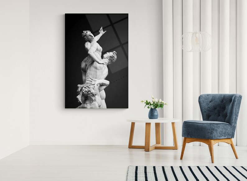Pu&ograve; includere: Fotografia in bianco e nero di una scultura di tre figure, due uomini e una donna, in una posa drammatica.